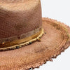 Detail view of a Valeria Andino Handmade Cattleman Straw Hat In a bronze colour with ruffled brim, course gold stitching and beautiful chain with nuggets and stones