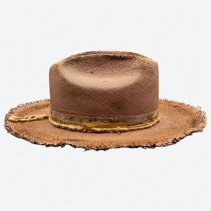Side view of a Valeria Andino Handmade Cattleman Straw Hat In a bronze colour with ruffled brim, course gold stitching and gold detailing