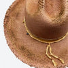 Detail view of a Valeria Andino Handmade Cattleman Straw Hat In a bronze colour with ruffled brim, course gold stitching and gold detailing