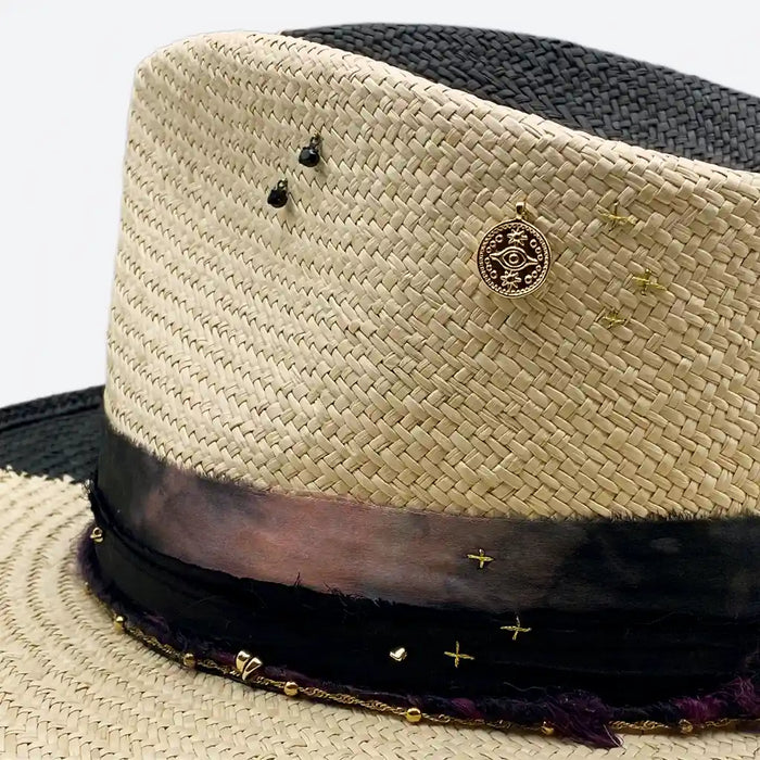 Detail view of a Valeria Andino split colour fedora straw hat with hand dyed silk trimmings, gold chain, dark studs with stitch details