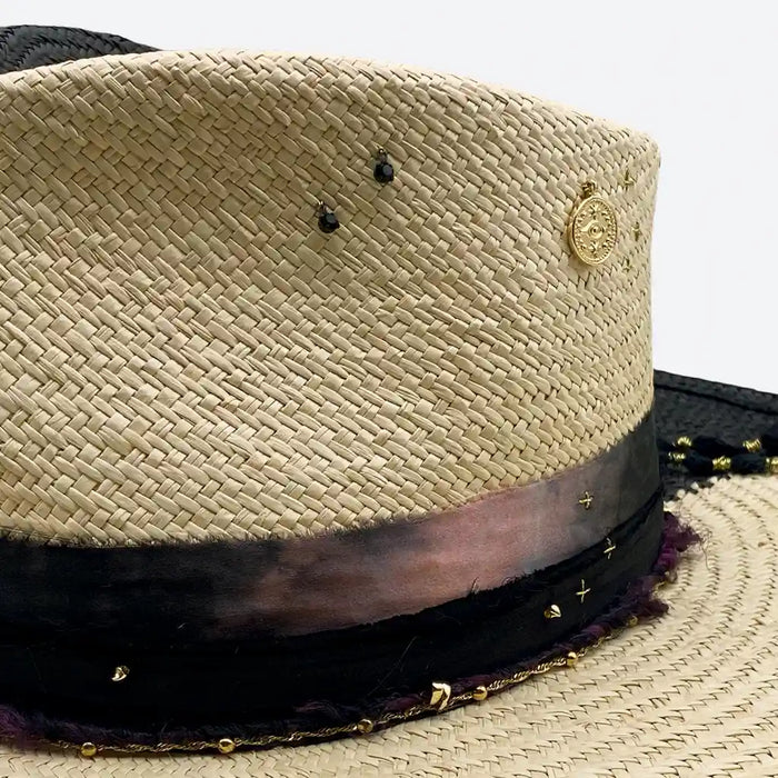 Detail view of a Valeria Andino split colour fedora straw hat with hand dyed silk trimmings, gold chain, dark studs with stitch details