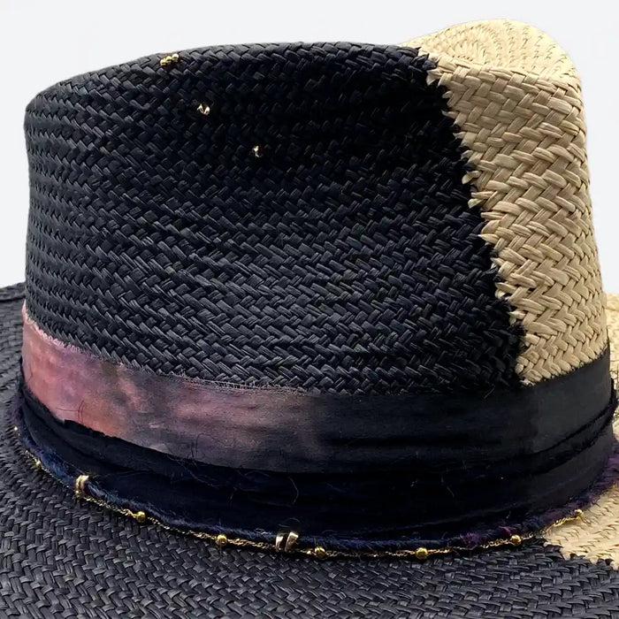 Detail view of a Valeria Andino split colour fedora straw hat with hand dyed silk trimmings, gold chain, dark studs with stitch details