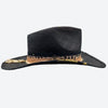 Side view of a Valeria Andino Handmade Straw Hat, its Classic cowboy shape in black with hand dyed silk trimmings, stones, gold jewelry & stitching
