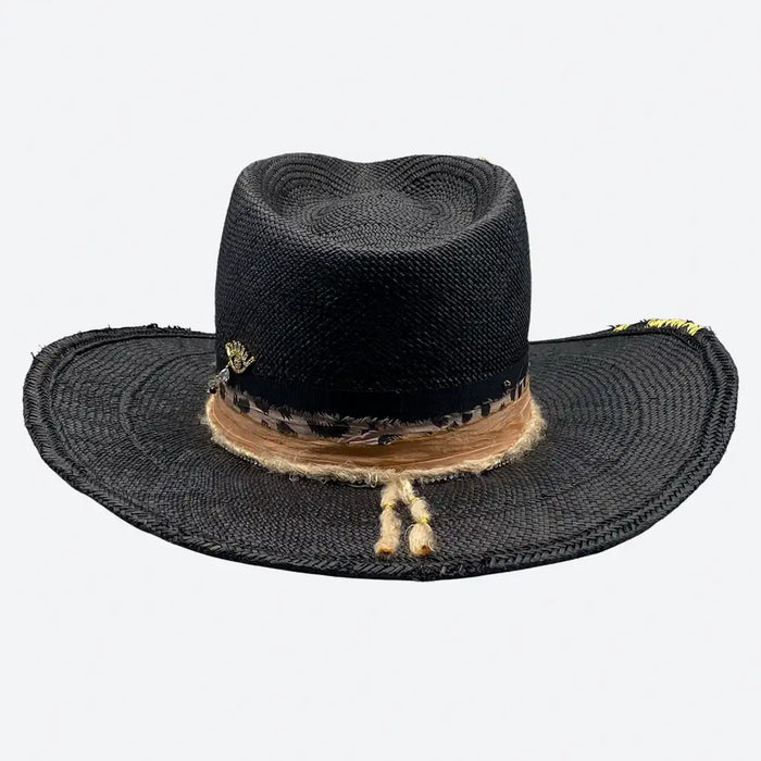 Rear view of a Valeria Andino Handmade Straw Hat, its Classic cowboy shape in black with hand dyed silk trimmings, stones and gold jewelry
